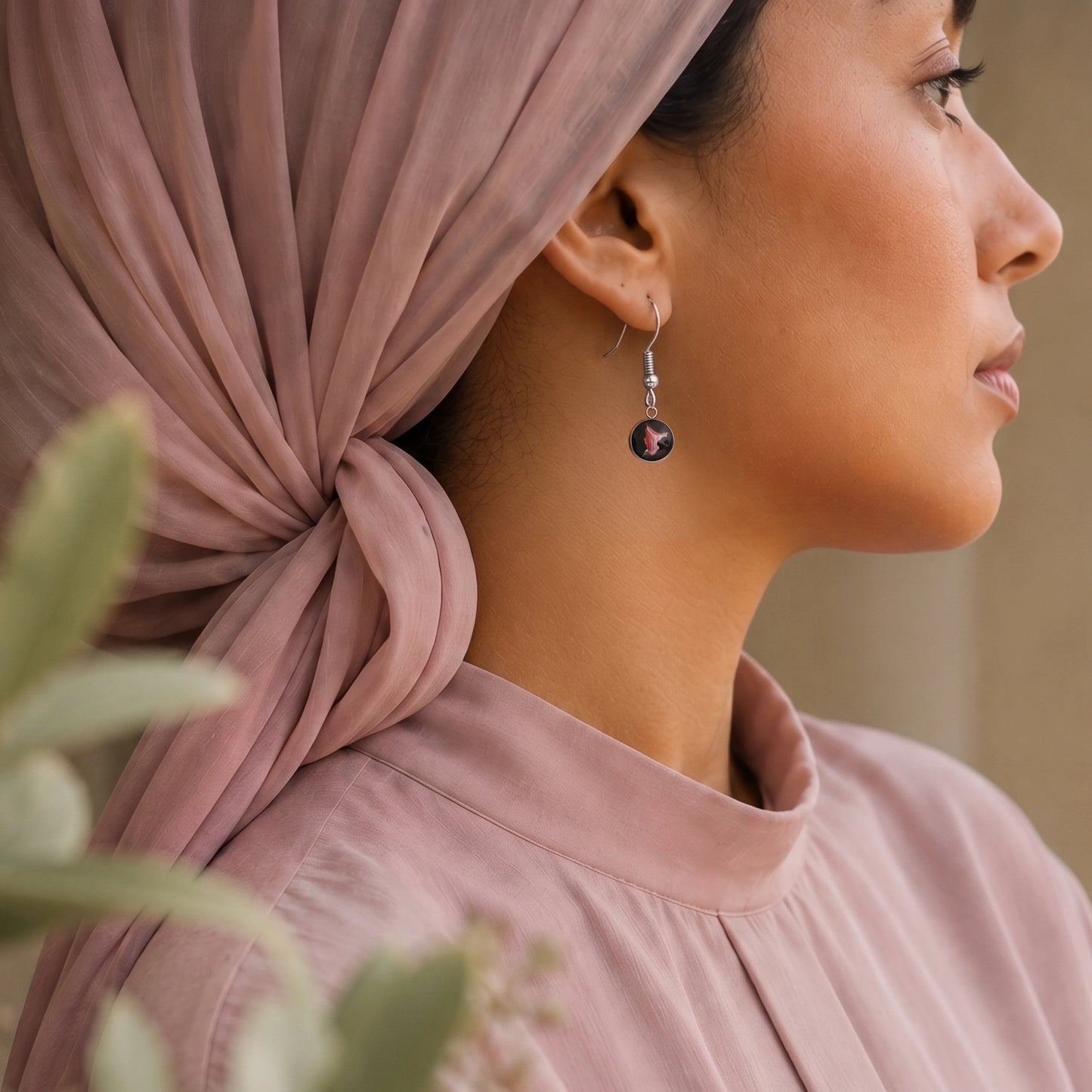 Model wearing Dar Suad stainless steel earrings featuring one-of-a-kind original artwork in black, red, and silver.