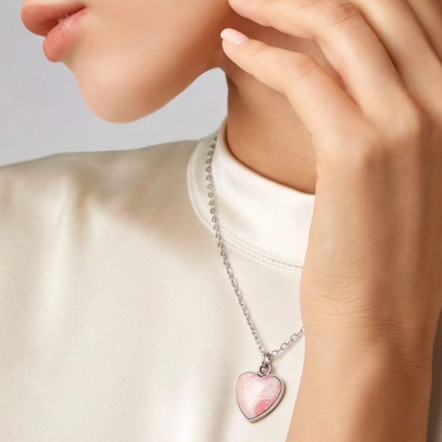 Model wearing a Dar Suad stainless steel necklace featuring one-of-a-kind artwork in pink and white.