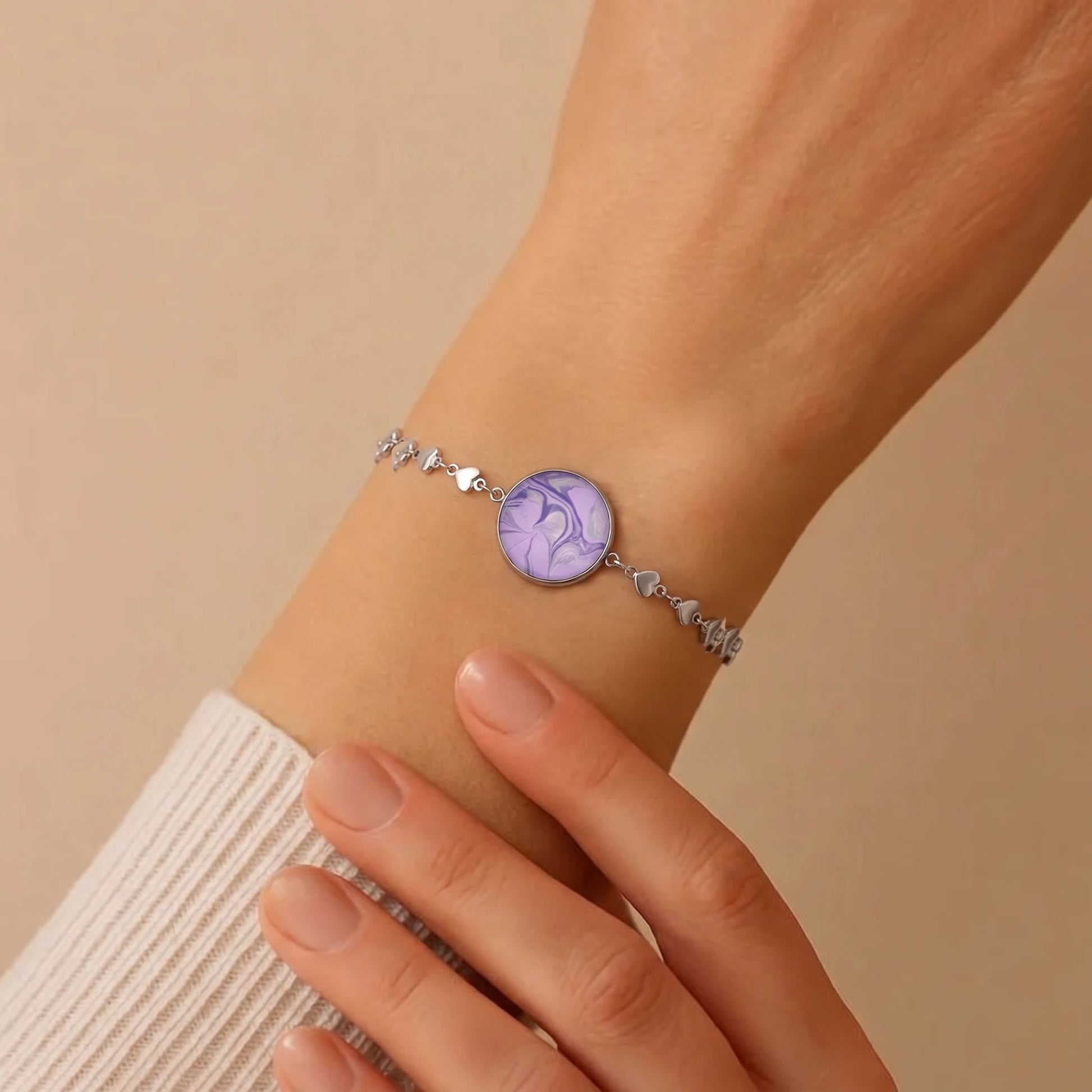 Model wearing Dar Suad stainless steel bracelet featuring marbling artwork in purple and silver.