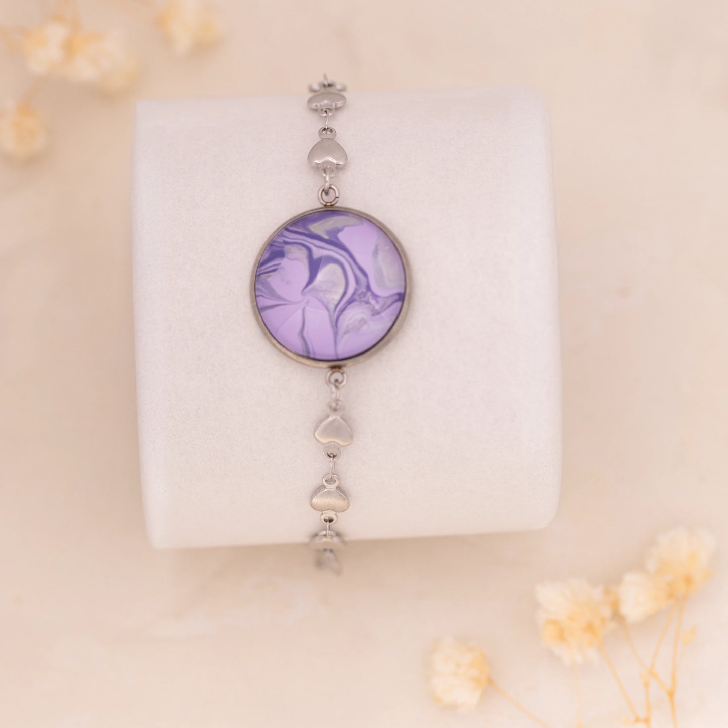 Dar Suad bracelet featuring marbling artwork in purple and silver with a stainless steel setting.