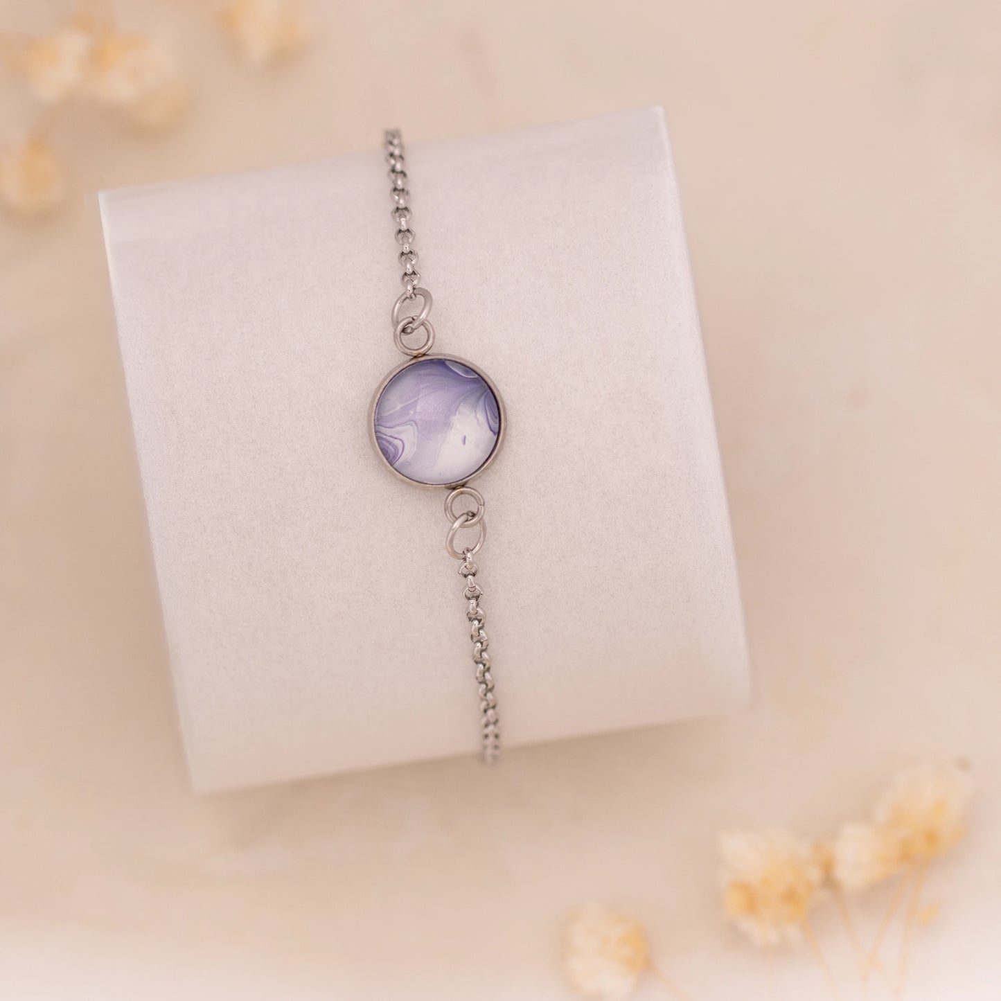 Dar Suad bracelet featuring marbling artwork in purple and white with a stainless steel setting.