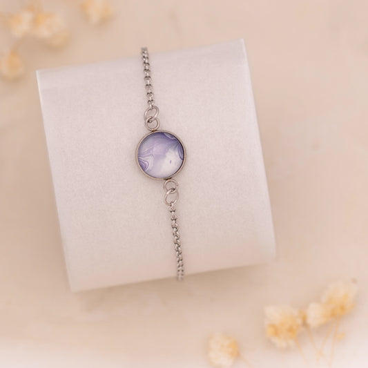 Dar Suad bracelet featuring marbling artwork in purple and white with a stainless steel setting.