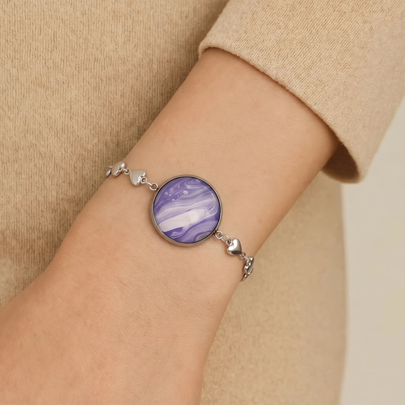 Model wearing Dar Suad stainless steel bracelet featuring marbling artwork in purple, white, and silver.