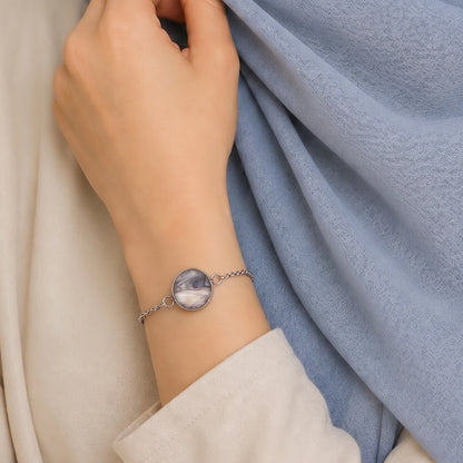 Model wearing Dar Suad stainless steel bracelet featuring marbling artwork in grey, silver, and beige.