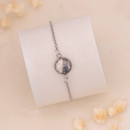 Dar Suad bracelet featuring marbling artwork in grey, silver, and beige with a stainless steel setting.