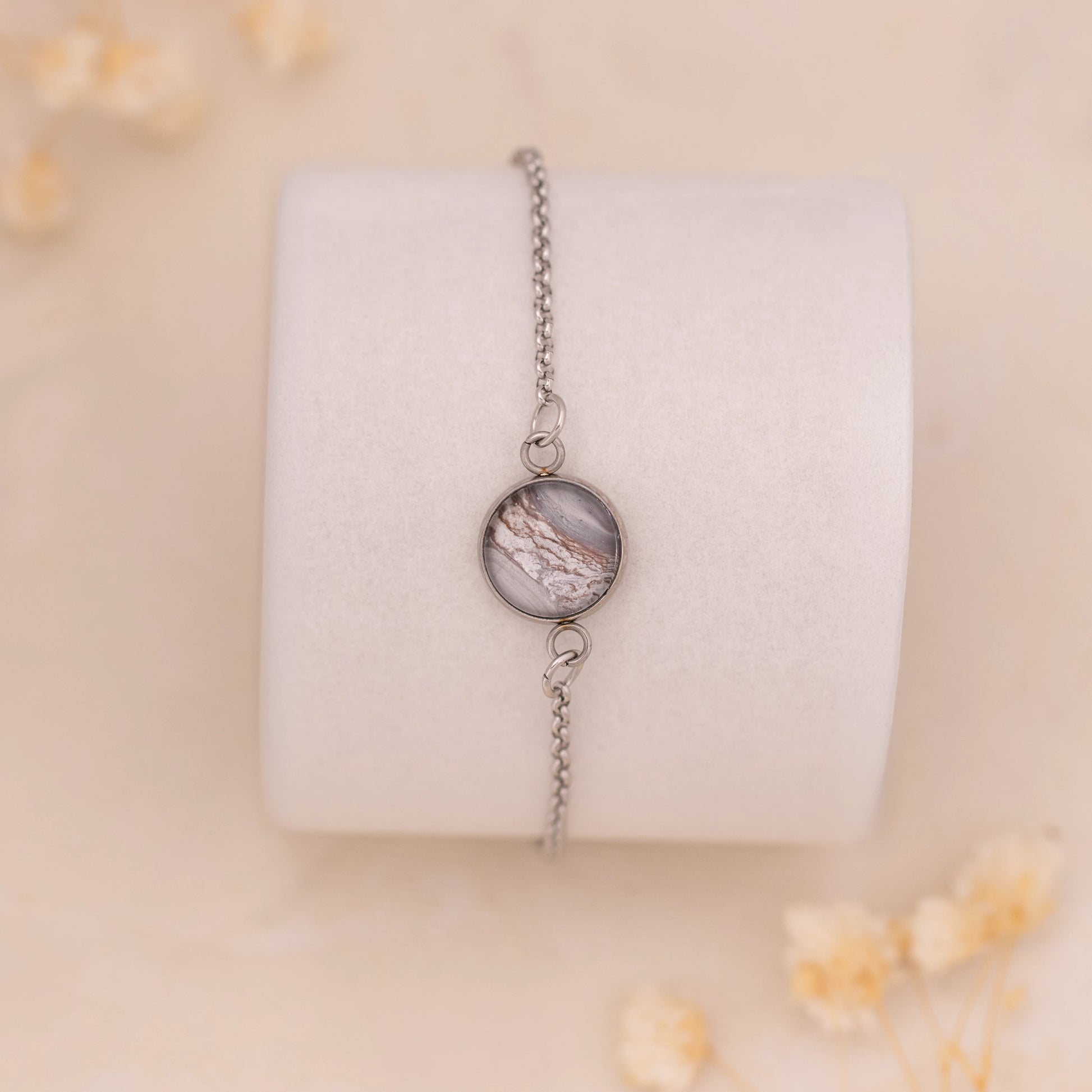 Dar Suad bracelet featuring marbling artwork in grey, brown, and white with a stainless steel setting.