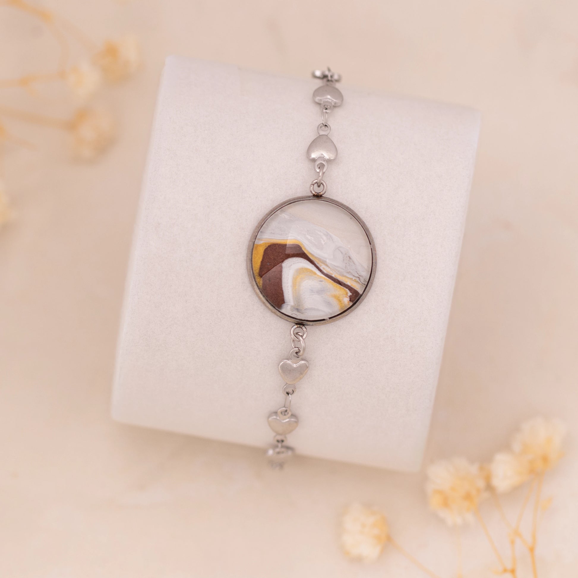 Dar Suad bracelet featuring marbling artwork in brown, yellow and white with a stainless steel setting.