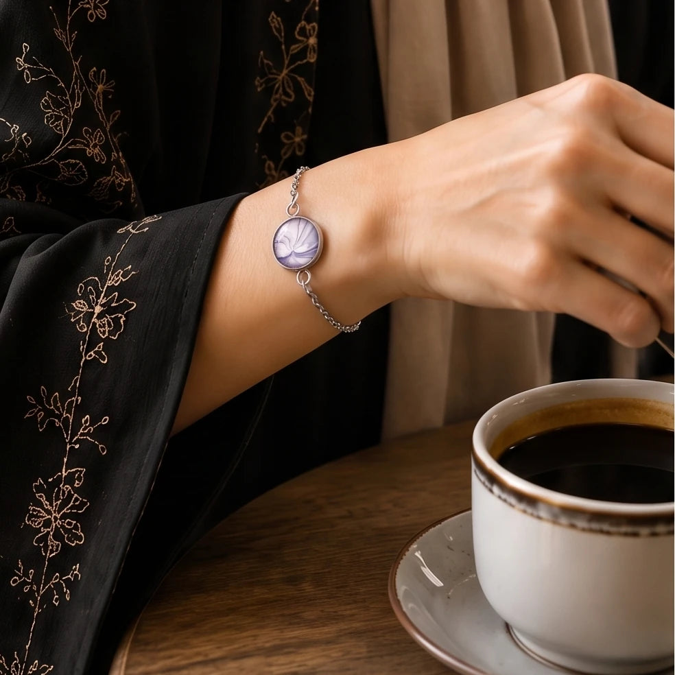 Model wearing Dar Suad stainless steel bracelet featuring marbling artwork in purple and white.