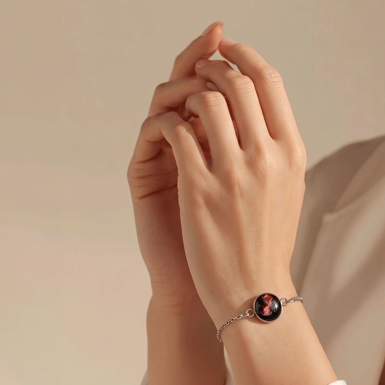 Model wearing Dar Suad stainless steel bracelet featuring abstract artwork in black, red, and silver.