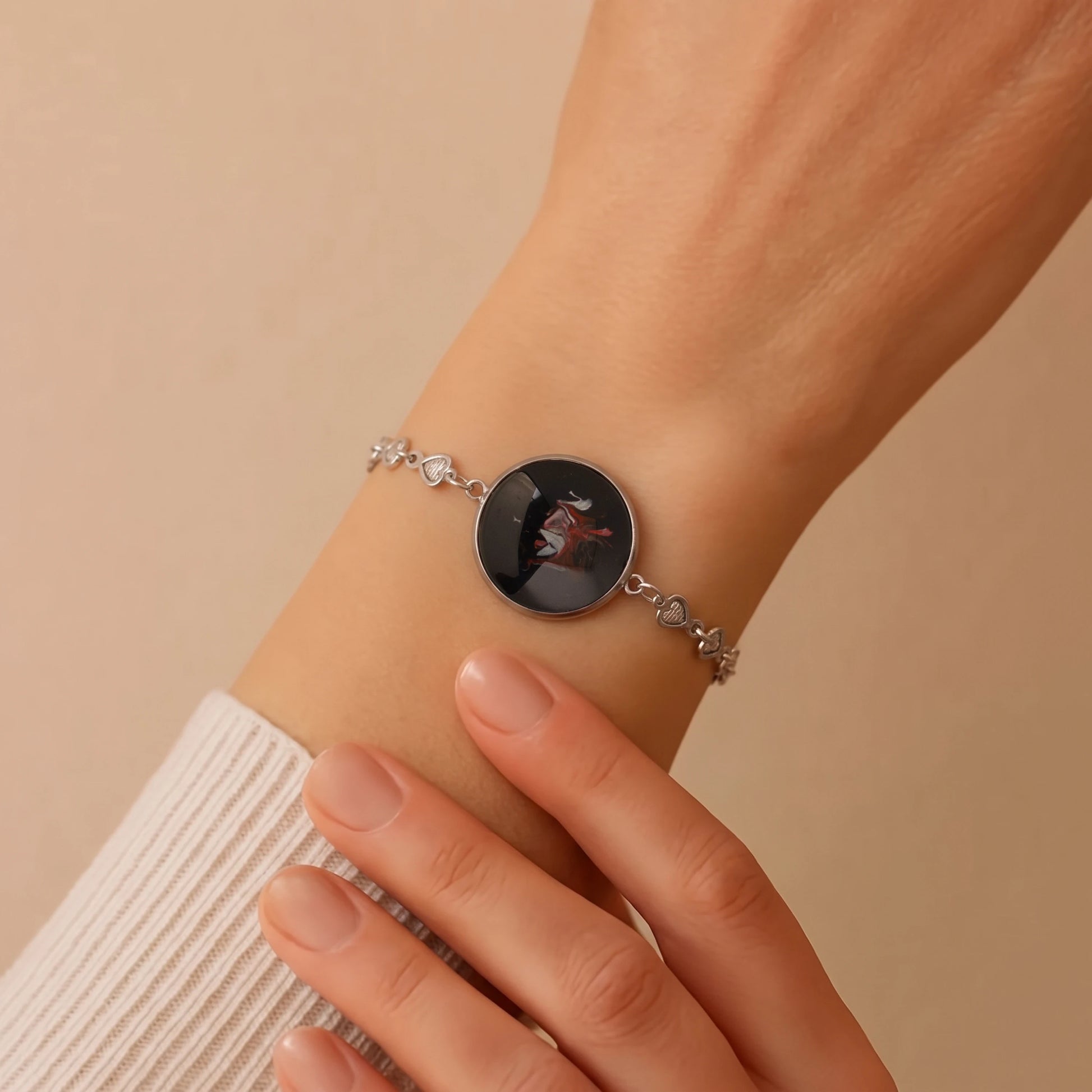 Model wearing Dar Suad stainless steel bracelet featuring one-of-a-kind original artwork in black, red, and silver.