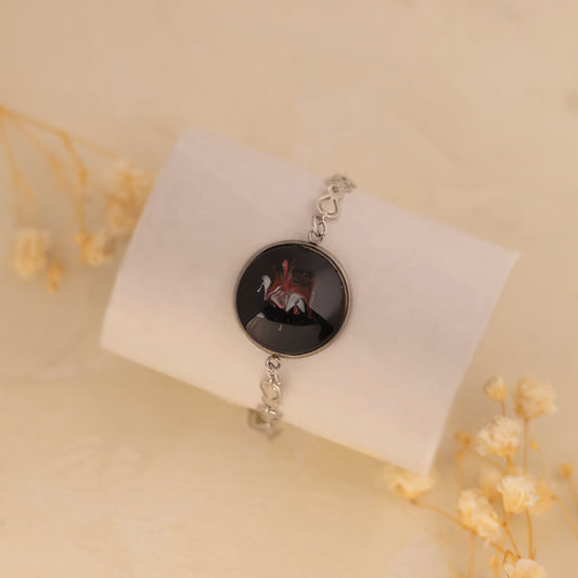 Dar Suad bracelet featuring one-of-a-kind original artwork in black, red, and silver with a stainless steel setting.