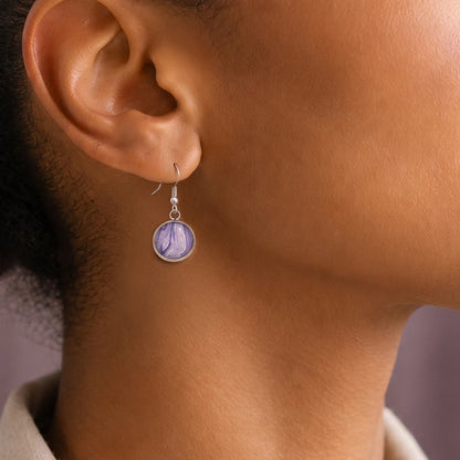 Model wearing Dar Suad stainless steel earrings featuring marbling artwork in purple and white.
