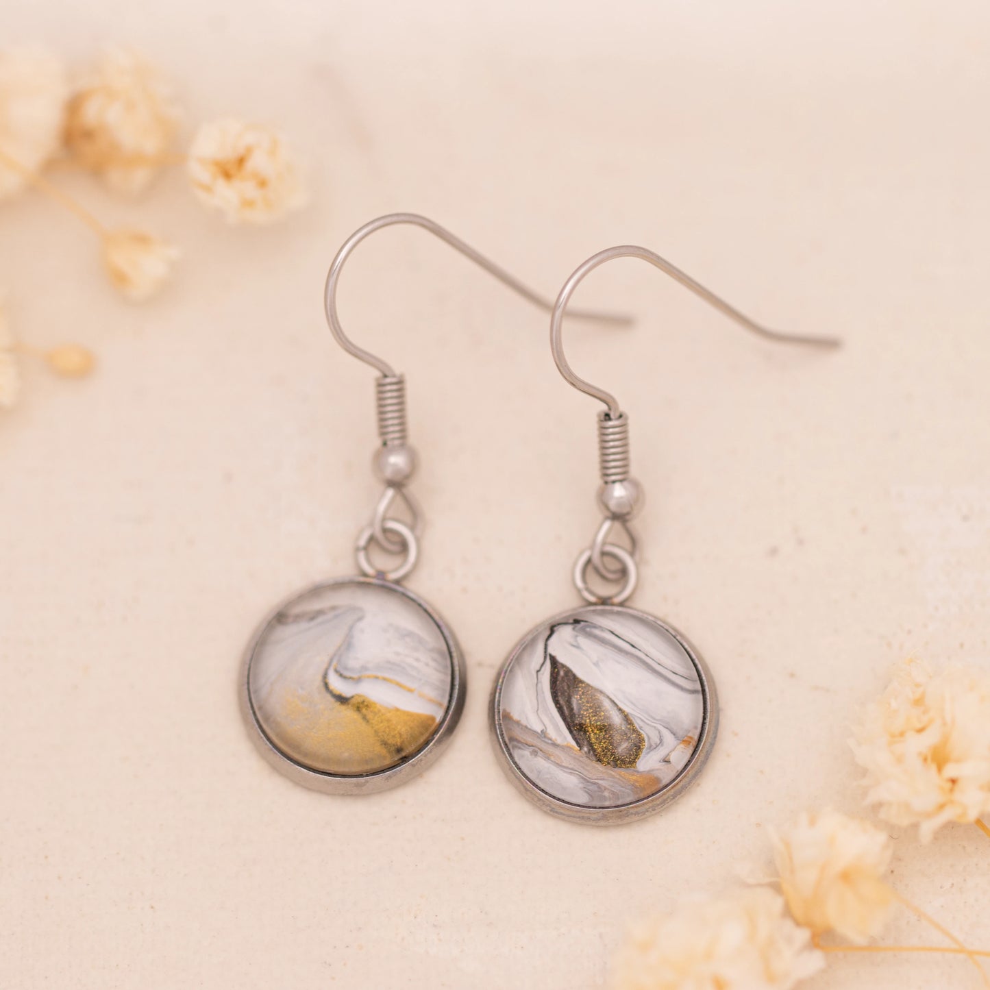 Dar Suad earrings featuring marbling artwork in white, grey, and bronze with a stainless steel setting.