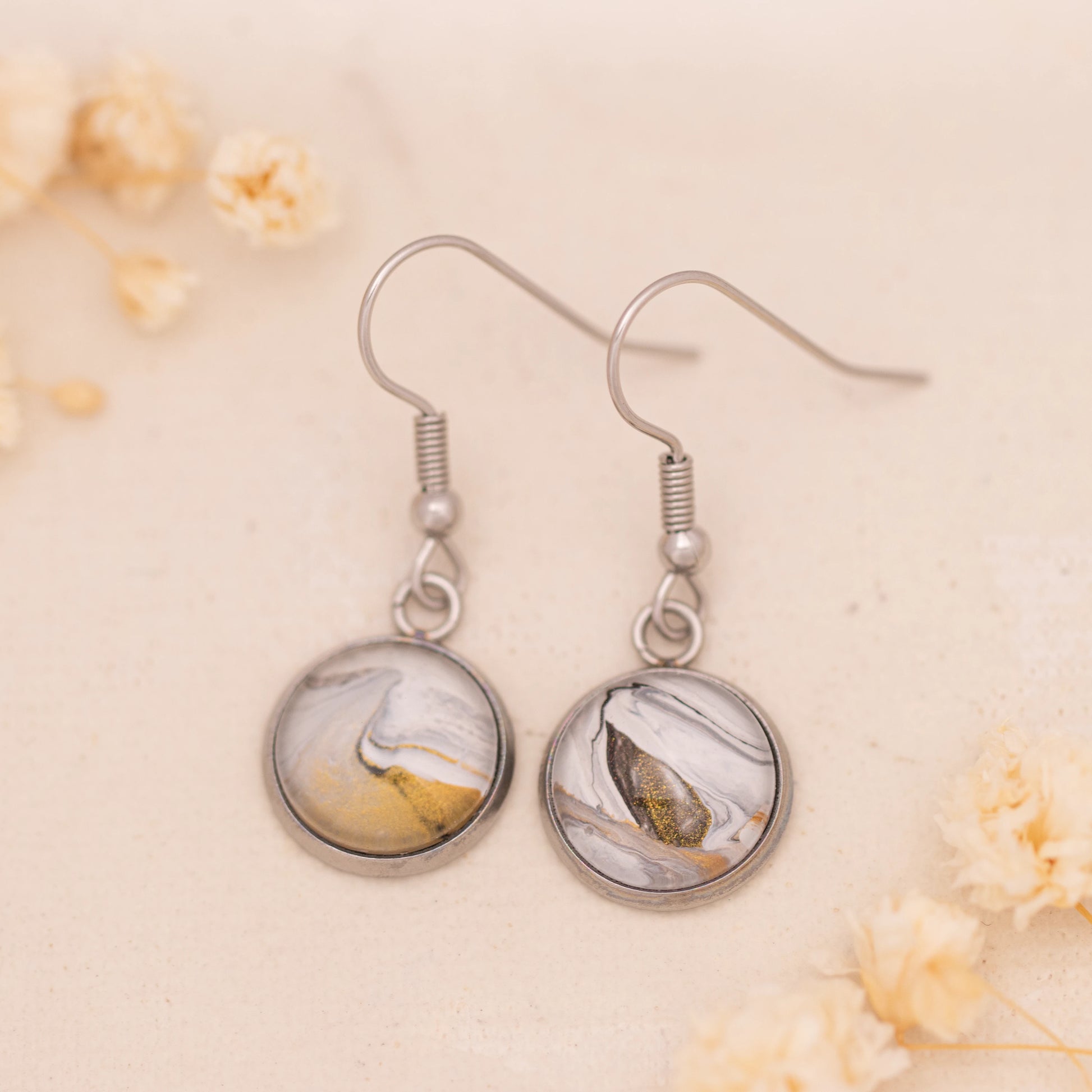 Dar Suad earrings featuring marbling artwork in white, grey, and bronze with a stainless steel setting.