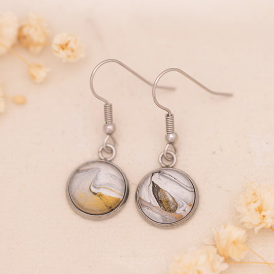 Dar Suad earrings featuring marbling artwork in white, grey, and bronze with a stainless steel setting.