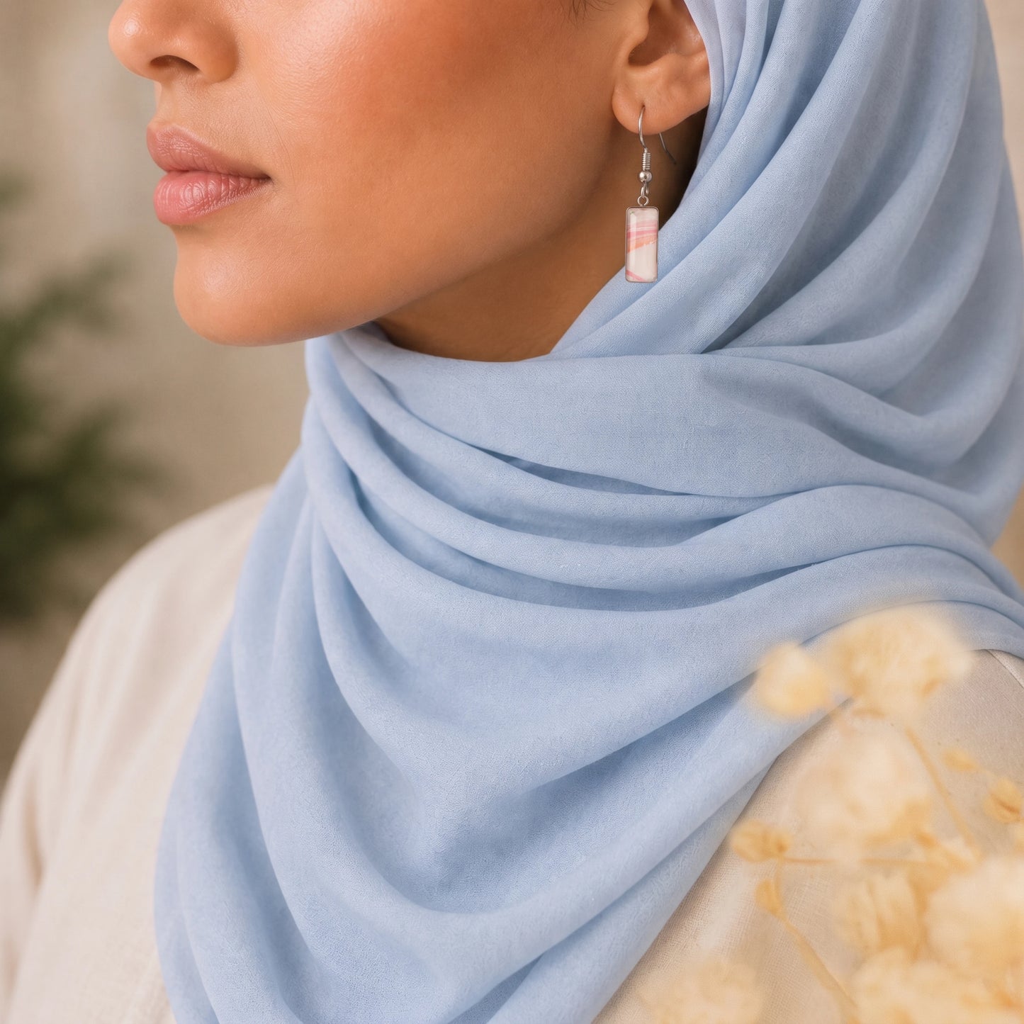 Model wearing Dar Suad stainless steel earrings featuring one-of-a-kind original artwork in pink and white.