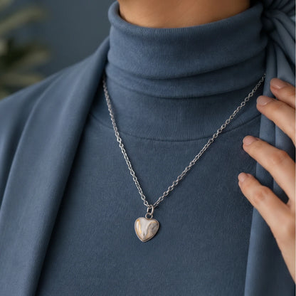 Model wearing Dar Suad stainless steel necklace featuring marbling artwork in white, yellow and grey.