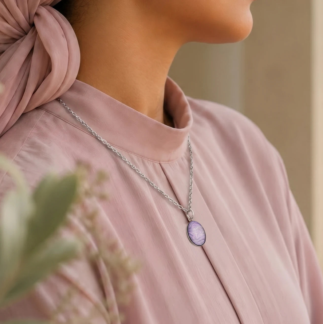 Model wearing Dar Suad stainless steel necklace featuring marbling artwork in purple and silver.
