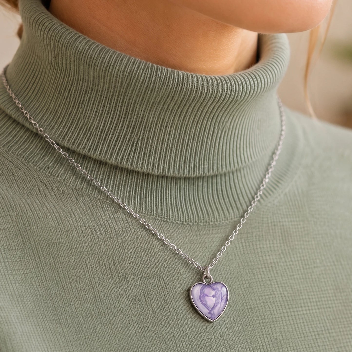 Model wearing Dar Suad stainless steel necklace featuring marbling artwork in purple and white.