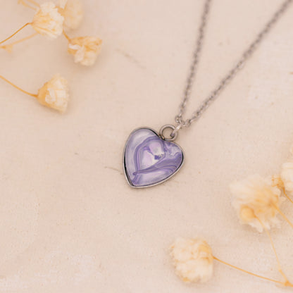 Dar Suad necklace featuring marbling artwork in purple and white with a stainless steel setting.