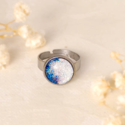 Dar Suad ring featuring one-of-a-kind original artwork in blue and white with a stainless steel setting.