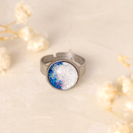 Dar Suad ring featuring one-of-a-kind original artwork in blue and white with a stainless steel setting.